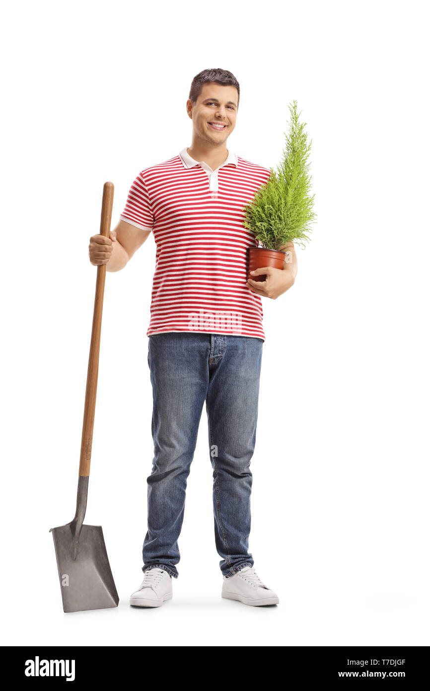 Full length portrait of a young man with a shovel and a plant isolated ...