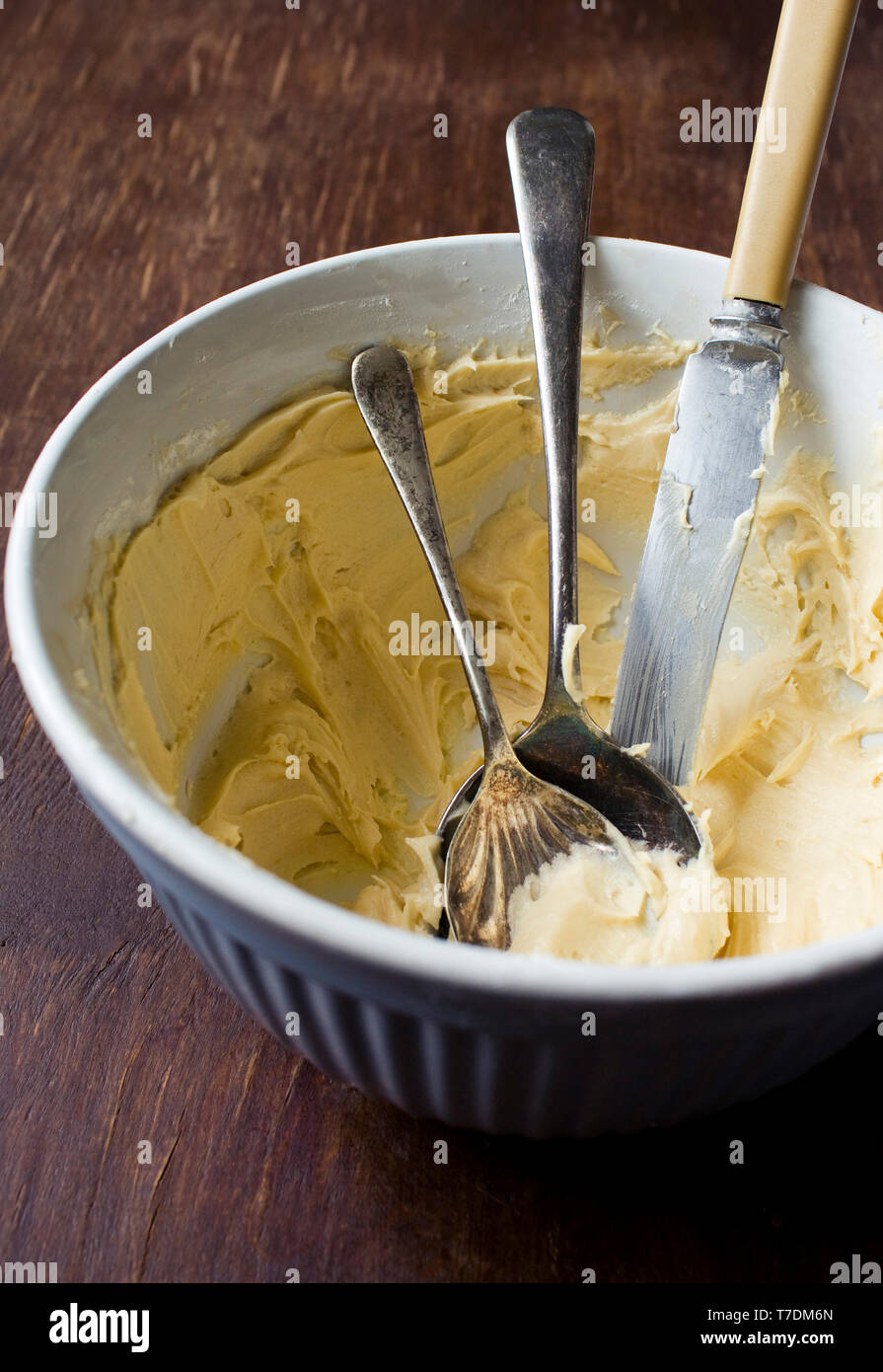 Ceramic Bowl of frosting with spoons and knife Stock Photo Alamy