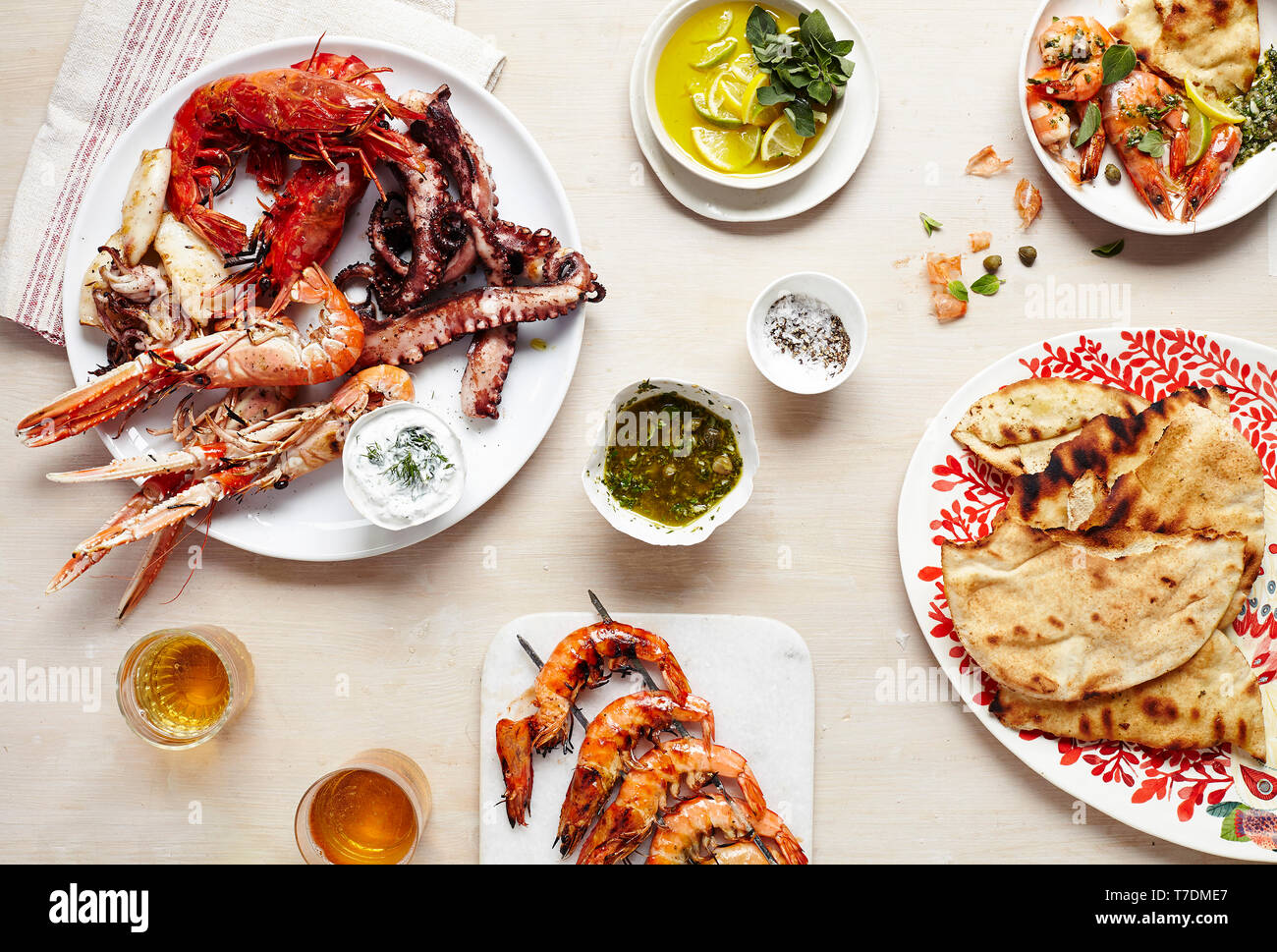 Tablescape featuring platters of fresh seafood and flatbread Stock Photo