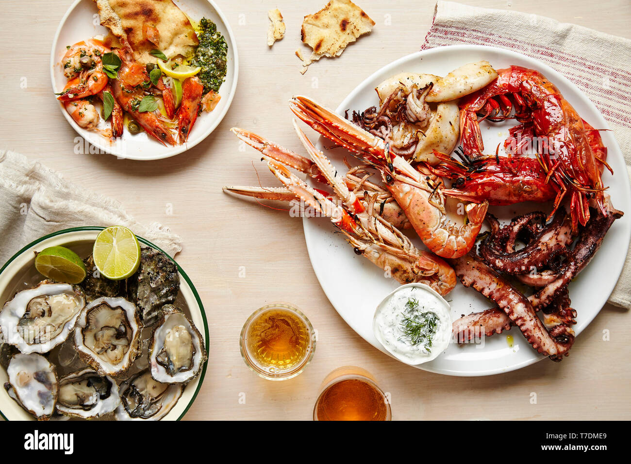 Tablescape featuring platters of fresh seafood and flatbread Stock Photo