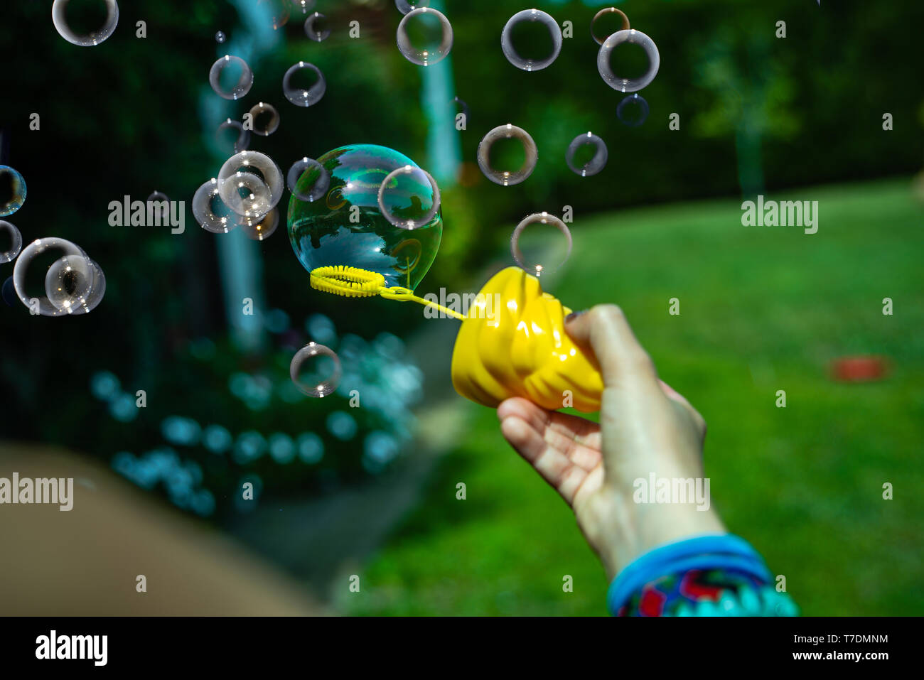 Little girl playing soap bubbles in the backyard in the sun Stock Photo ...