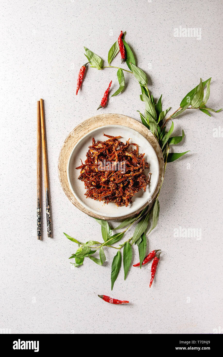 Vietnamese traditional hot spicy anchovies fish snack in ceramic plates