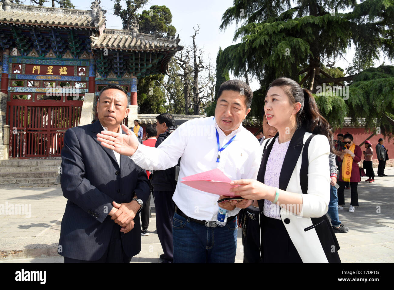 (190506) -- ZOUCHENG, May 6, 2019 (Xinhua) -- Meng Xing (R, front), the 72nd-generation descendant of ancient China's philosopher Mencius, talks with guests who come to attend the commemoration ceremony of Mencius and Mencius' mother at Mencius Temple in Zoucheng City, east China's Shandong Province, May 6, 2019. Living in a community near Mencius Temple, 37-year-old Meng Xing is in charge of the maintenance of Mencius Temple, Mencius Mansion and Mencius Cemetery. (Xinhua/Wang Kai) Stock Photo