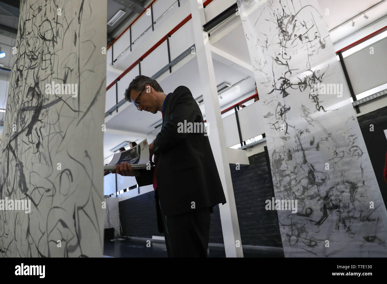 (190507) -- BRUSSELS, May 7, 2019 (Xinhua) -- A visitor views works during the 'Written Landscape, Painted Writing' exhibition in Brussels, Belgium, May 6, 2019. A series of events on contemporary ink entitled 'INK Brussels 2019/Week of Ink' were held at the Faculty of Architecture of the ULB (Universite libre de Bruxelles) since Monday. Featuring an exhibition 'Written Landscape, Painted Writing' and several conferences and workshops, INK Brussels 2019 aims to explore the role ink painting and calligraphy plays in abstractionism. With works of ink from 50 artists, the exhibition will last unt Stock Photo