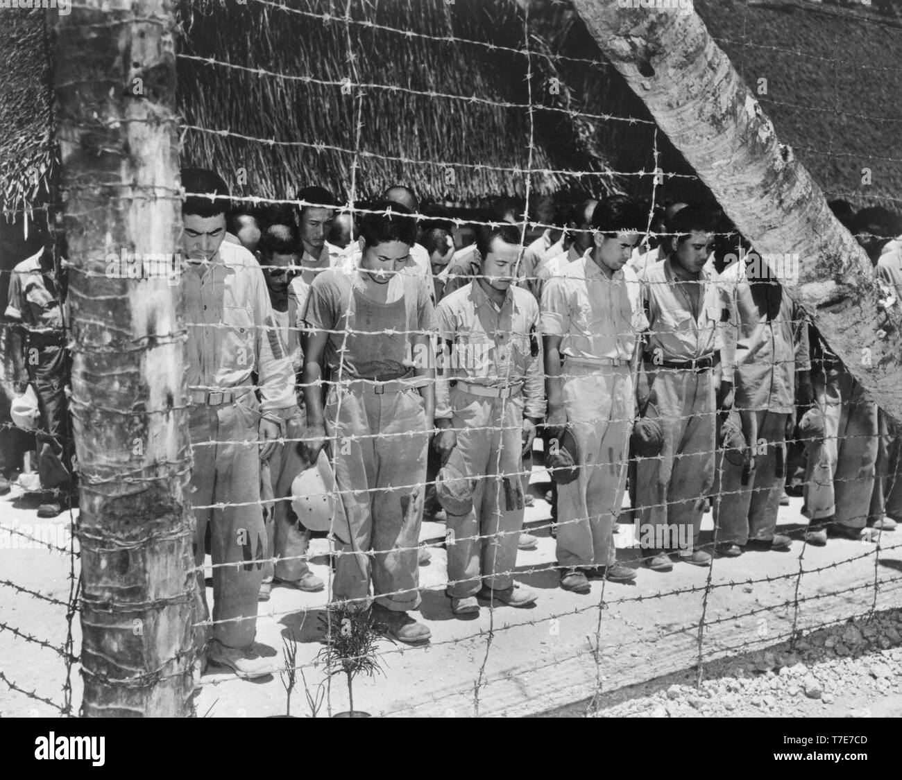 Japanese POW, with heads bowed after hearing Emperor Hirohito make Announcement of Japan's Unconditional Surrender, Guam, U.S. Navy Photo, August 15, 1945 Stock Photo