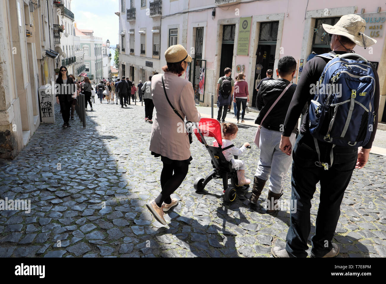 Tourist family parents children people walking on cobbled street with