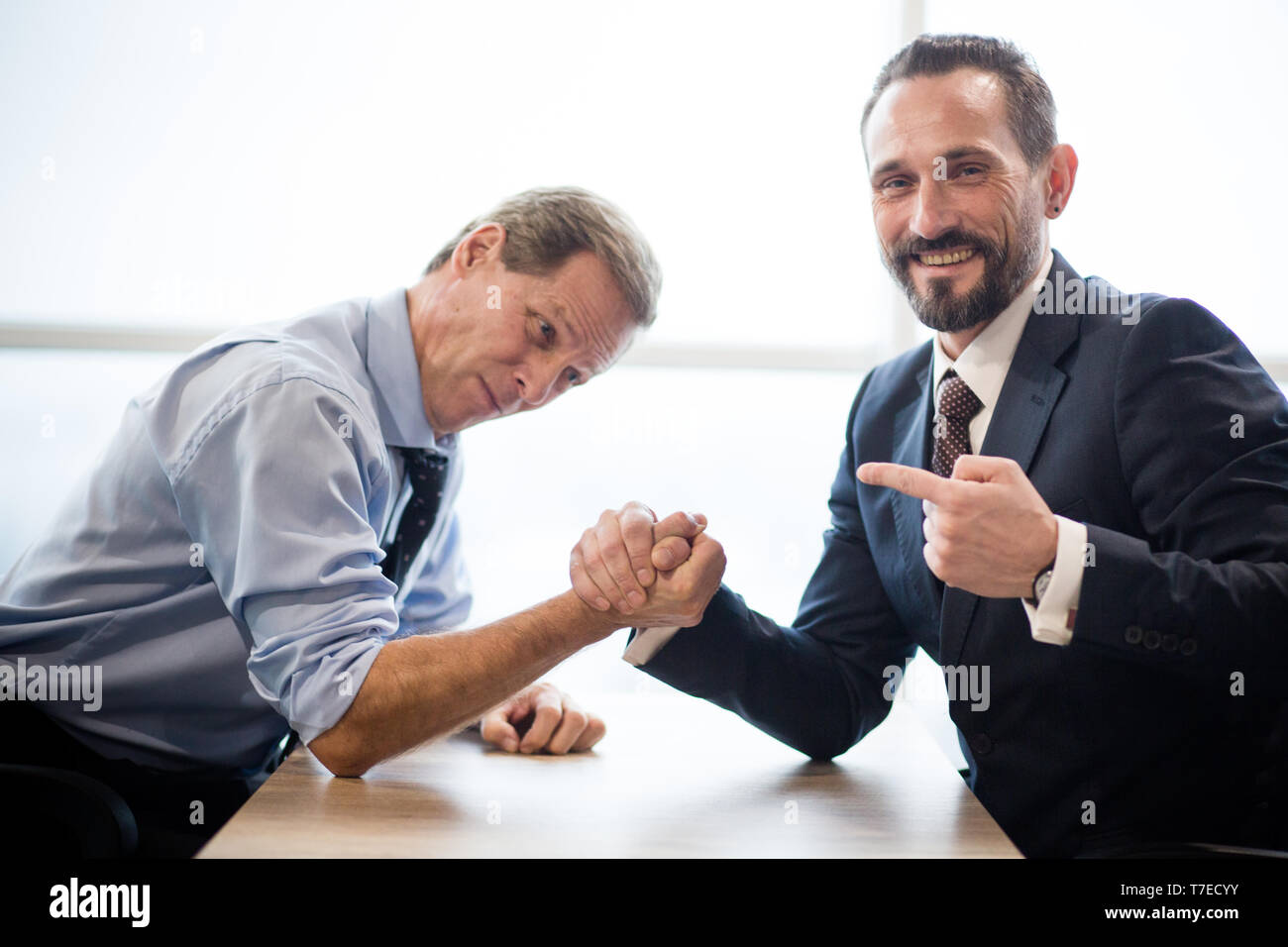 Two businessmen doing arm wrestling in office Stock Photo