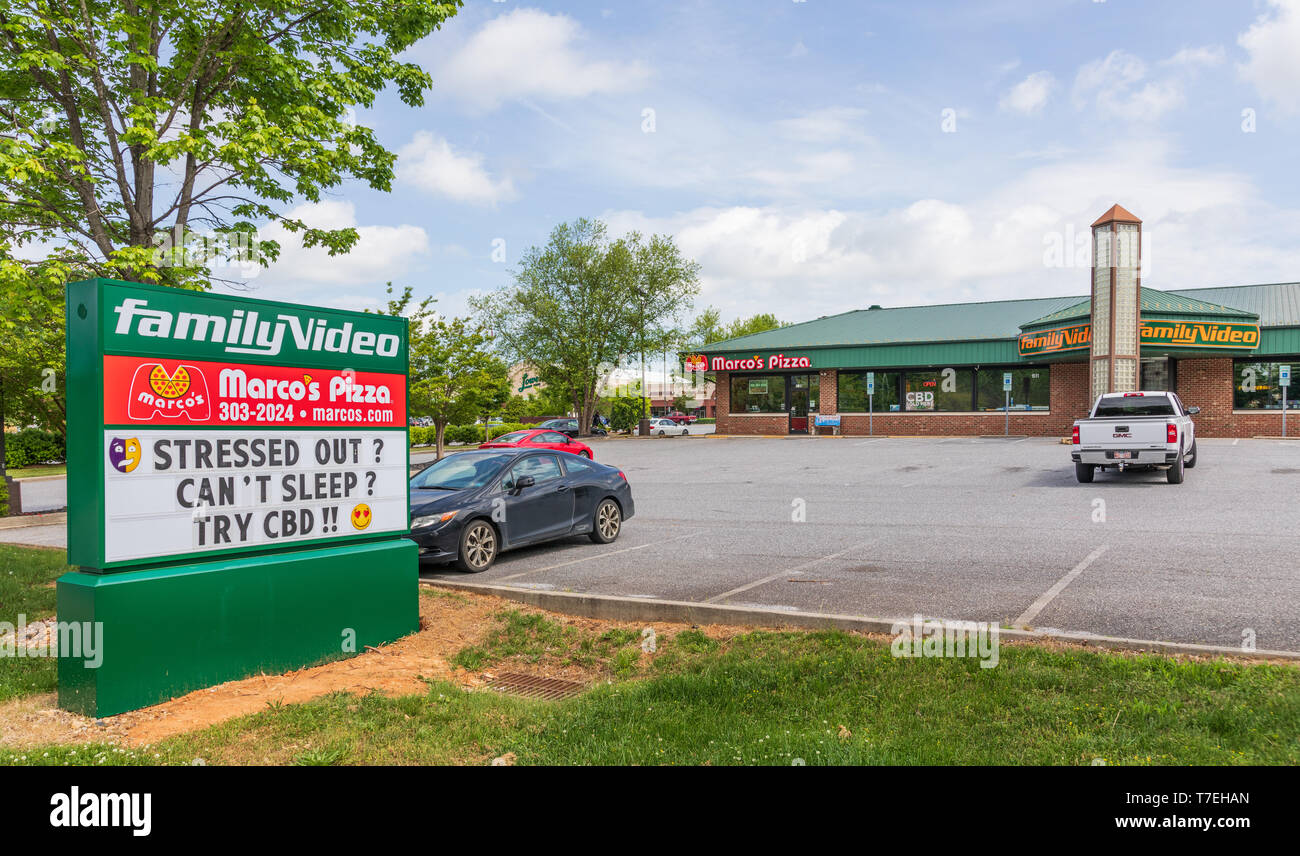 HICKORY, NC, USA-5/3/19: A Family Video store, with street sign advertising CBD (cannabidiol) for sale. Stock Photo