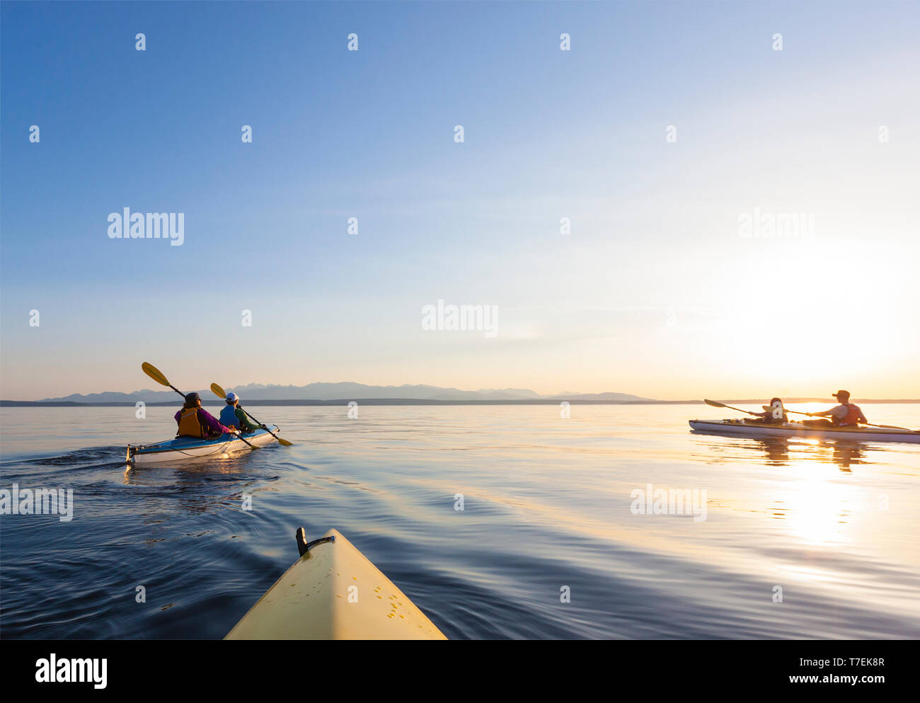 Group of people friends sea kayaking off Whidbey Island in Puget Sound, Washington State. Active outdoor adventure water sports. Stock Photo