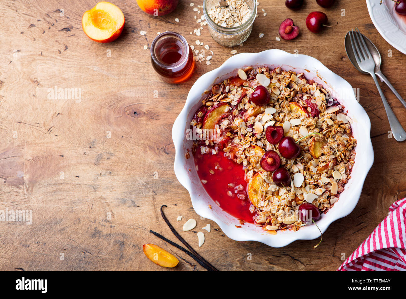 Peach and berry crumble in a baking dish. Top view. Copy space. Stock Photo