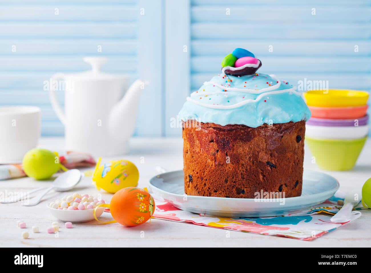 Easter cake with colorful eggs. White and blue wooden background. Copy space Stock Photo