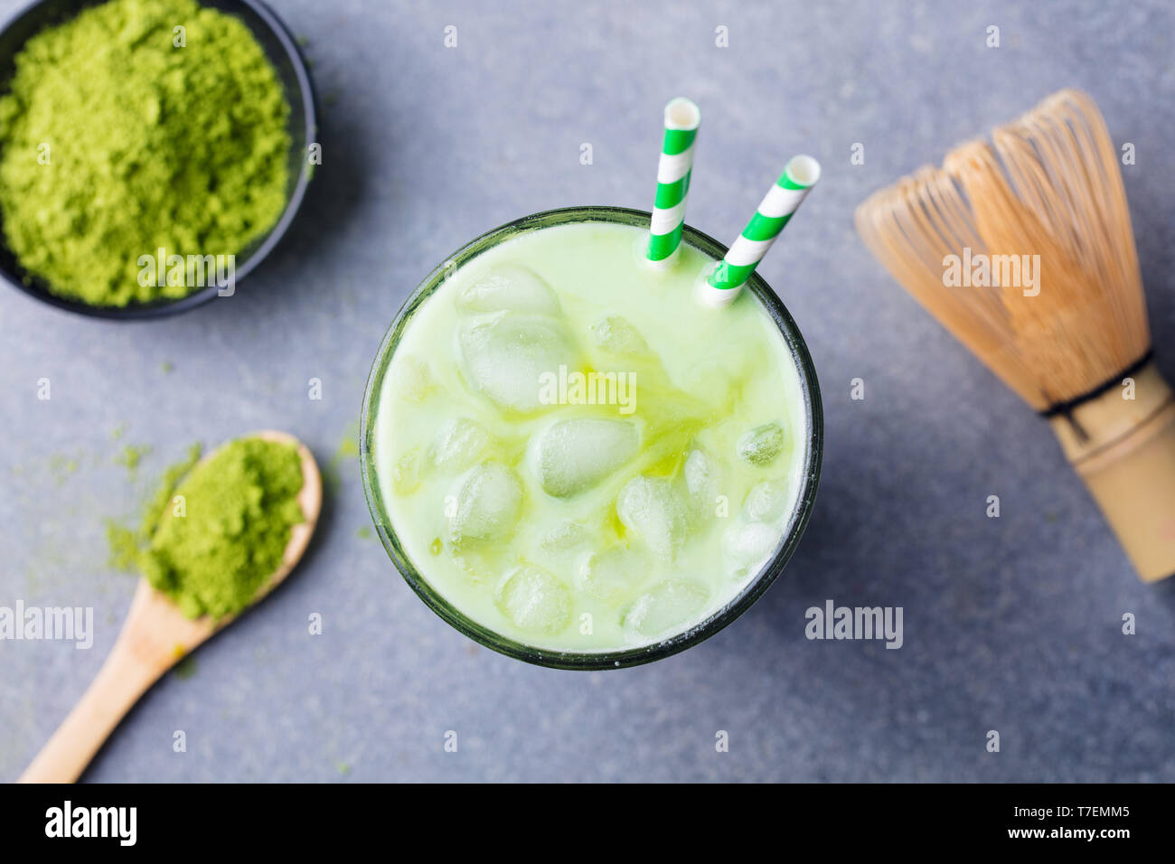 Matcha green tea ice latte with matcha powder and bamboo whisk. Top