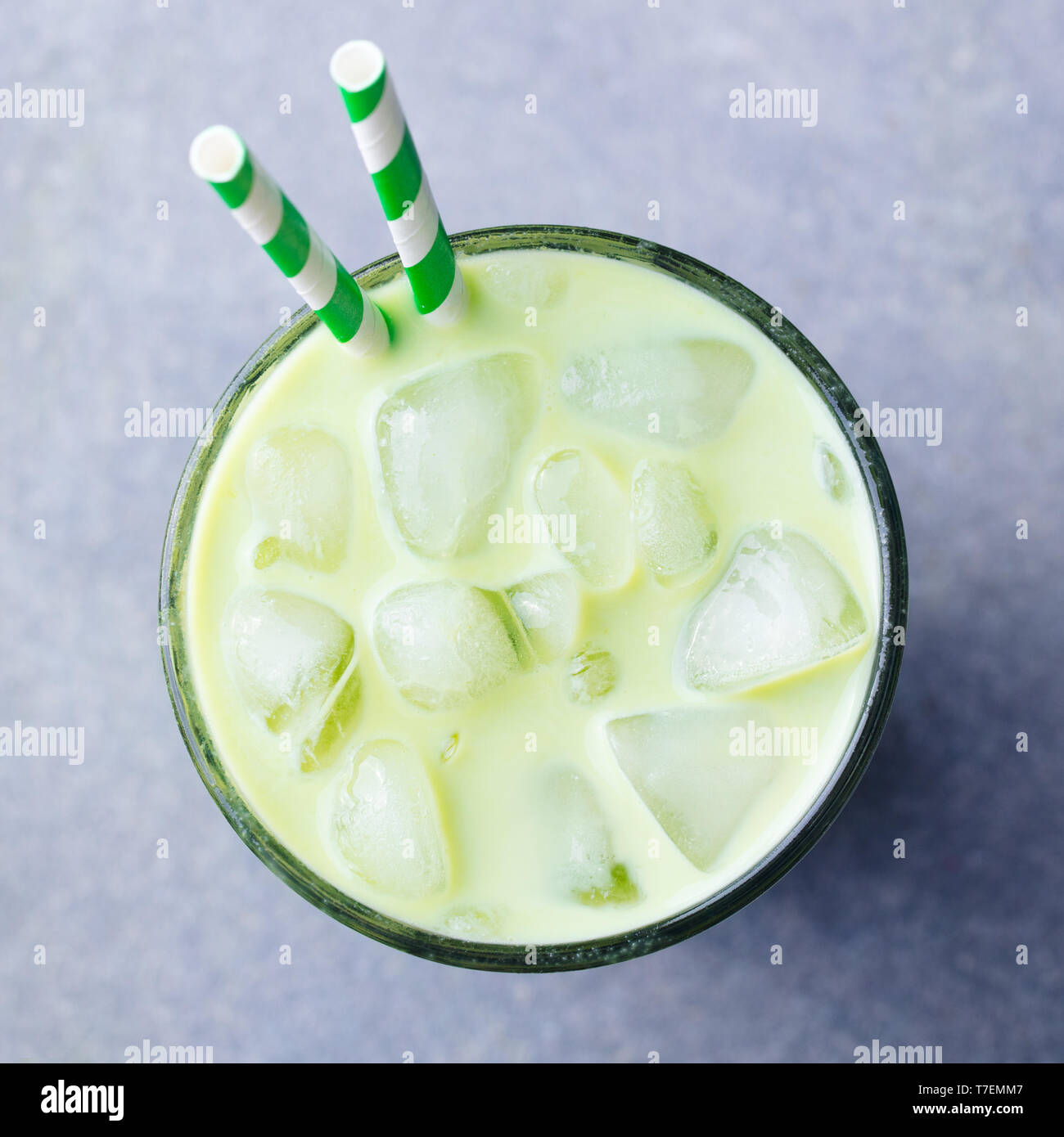 Matcha green tea ice latte in a glass. Grey stone background. Top view. Stock Photo