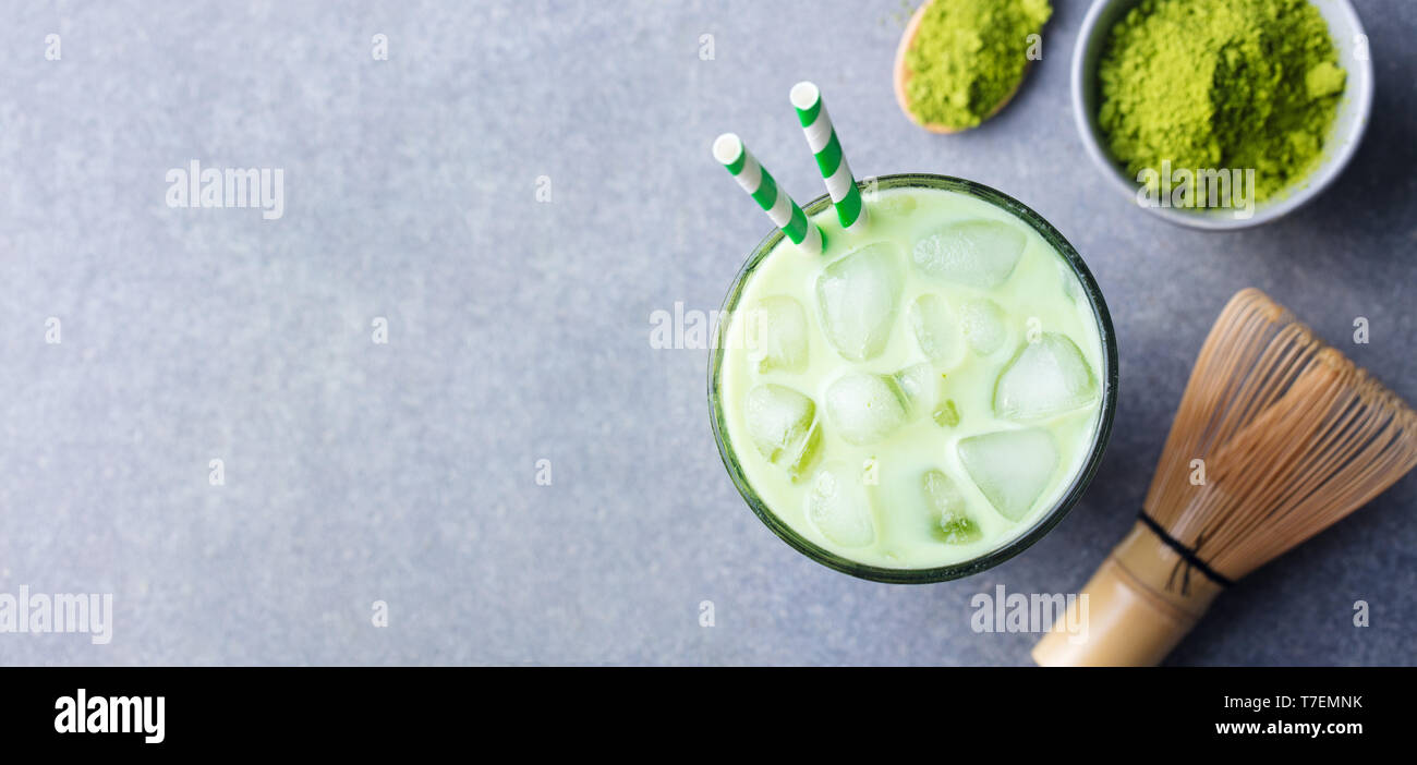 Matcha green tea ice latte with matcha powder and bamboo whisk. Top