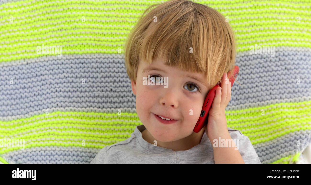 Little smiling child boy hand holding mobile phone Stock Photo