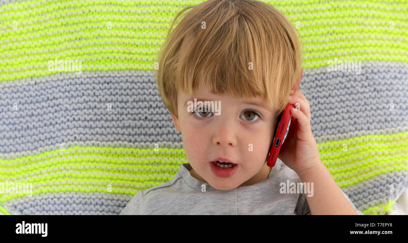 Little smiling child boy hand holding mobile phone Stock Photo