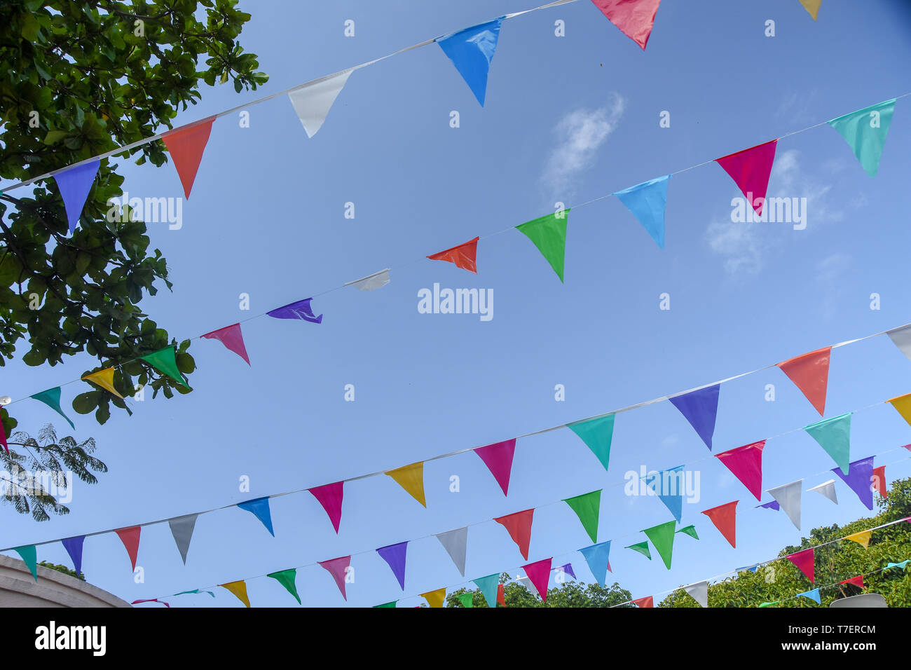 low angle view of colorful flags against blue sky Stock Photo