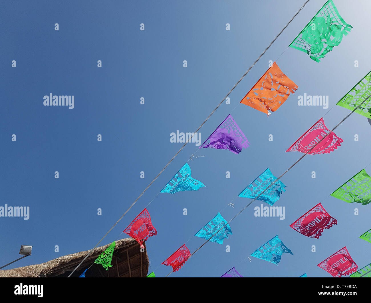 low angle view of colorful flags against blue sky Stock Photo