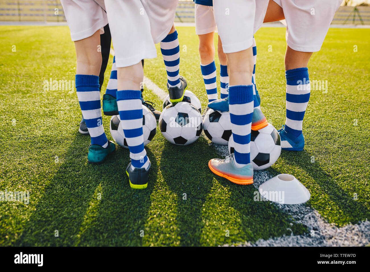 Group of young football players on soccer training. Legs of soccer kids