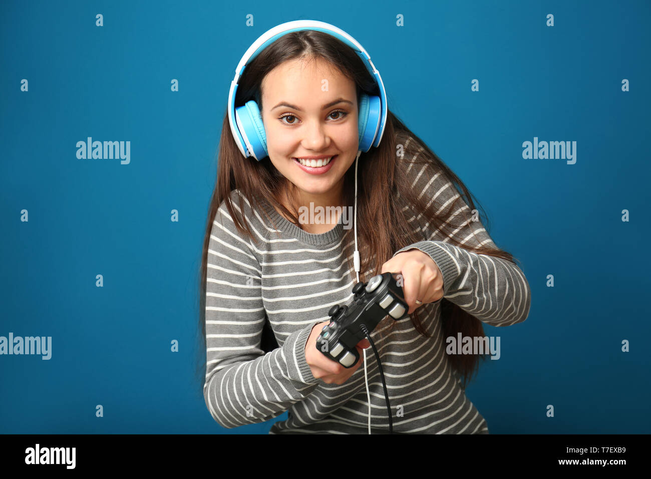 Cute girl with gamepad on color background Stock Photo - Alamy