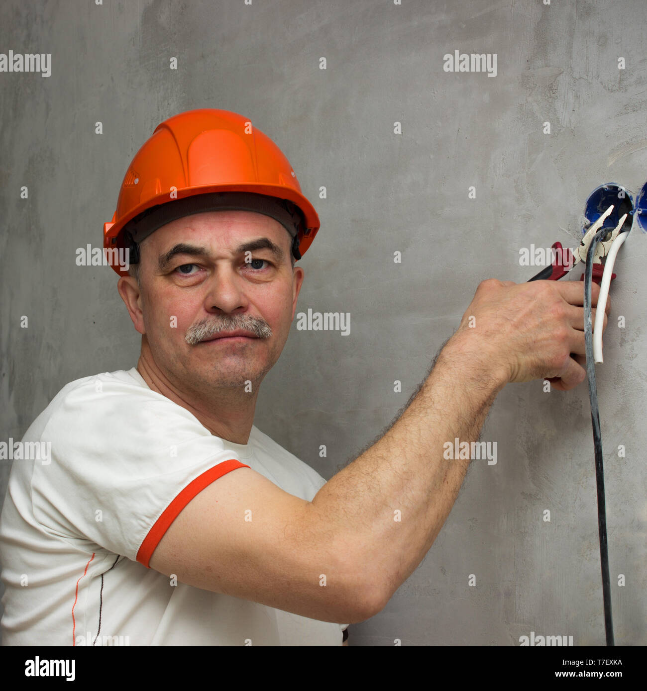 Strange man with a stern face cuts the wiring. Produces deversion Stock Photo