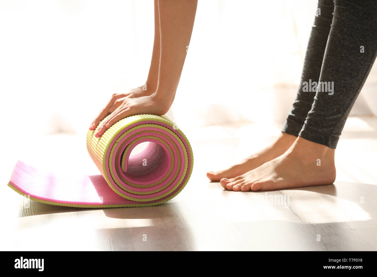 Young woman with yoga mat indoors Stock Photo - Alamy