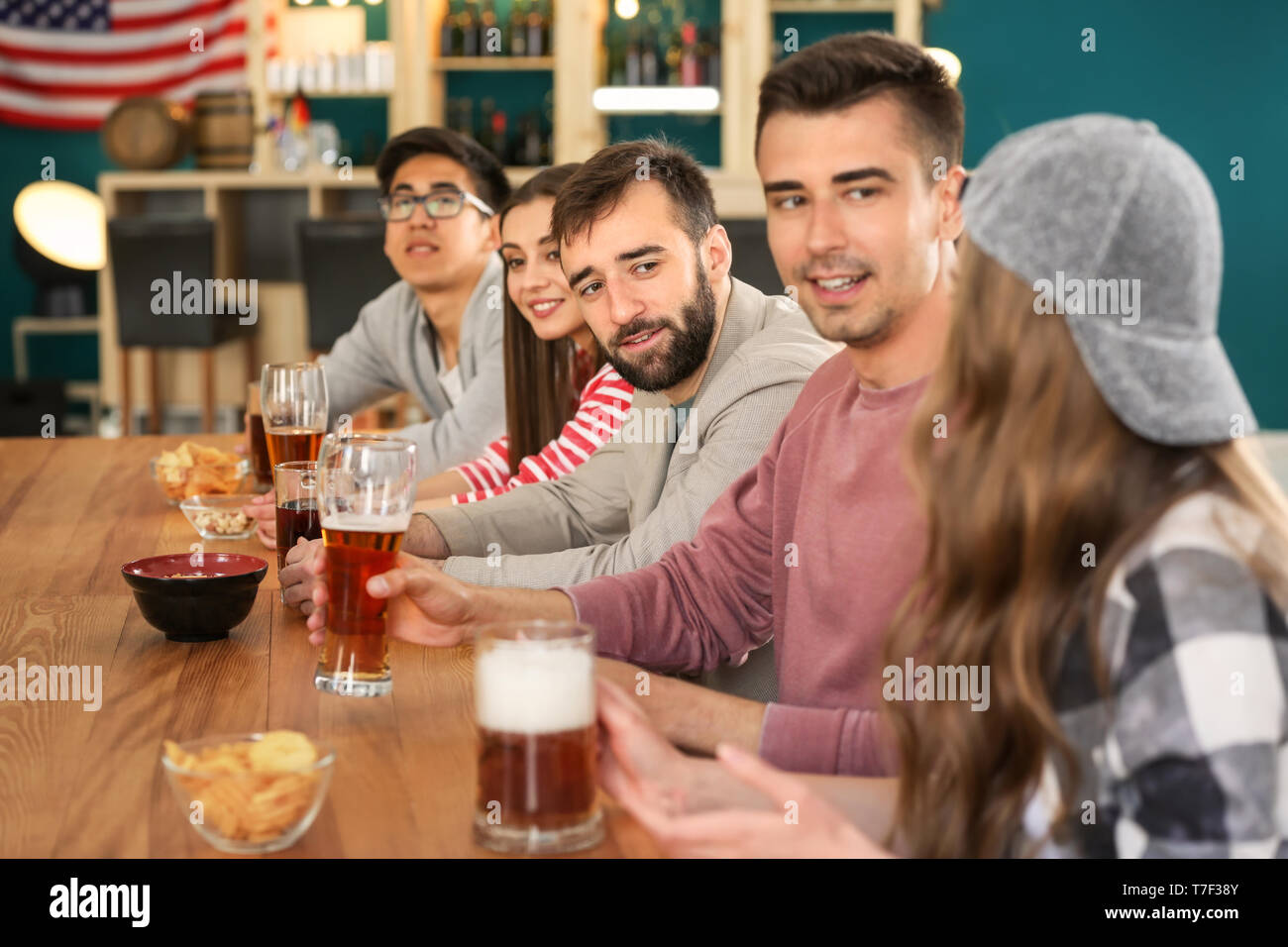 Group of friends drinking beer in bar Stock Photo - Alamy