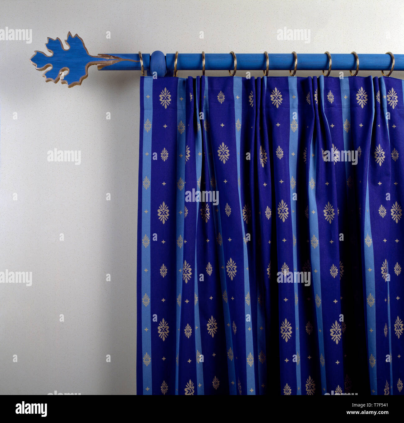 Patterned Blue Curtain On Blue Pole With Blue Leaf Finial Stock