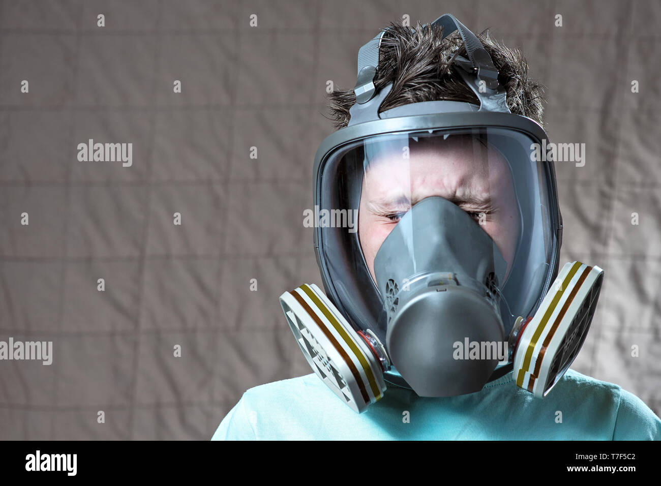 closeup portrait of a boy in a light tshirt with a gas mask Stock