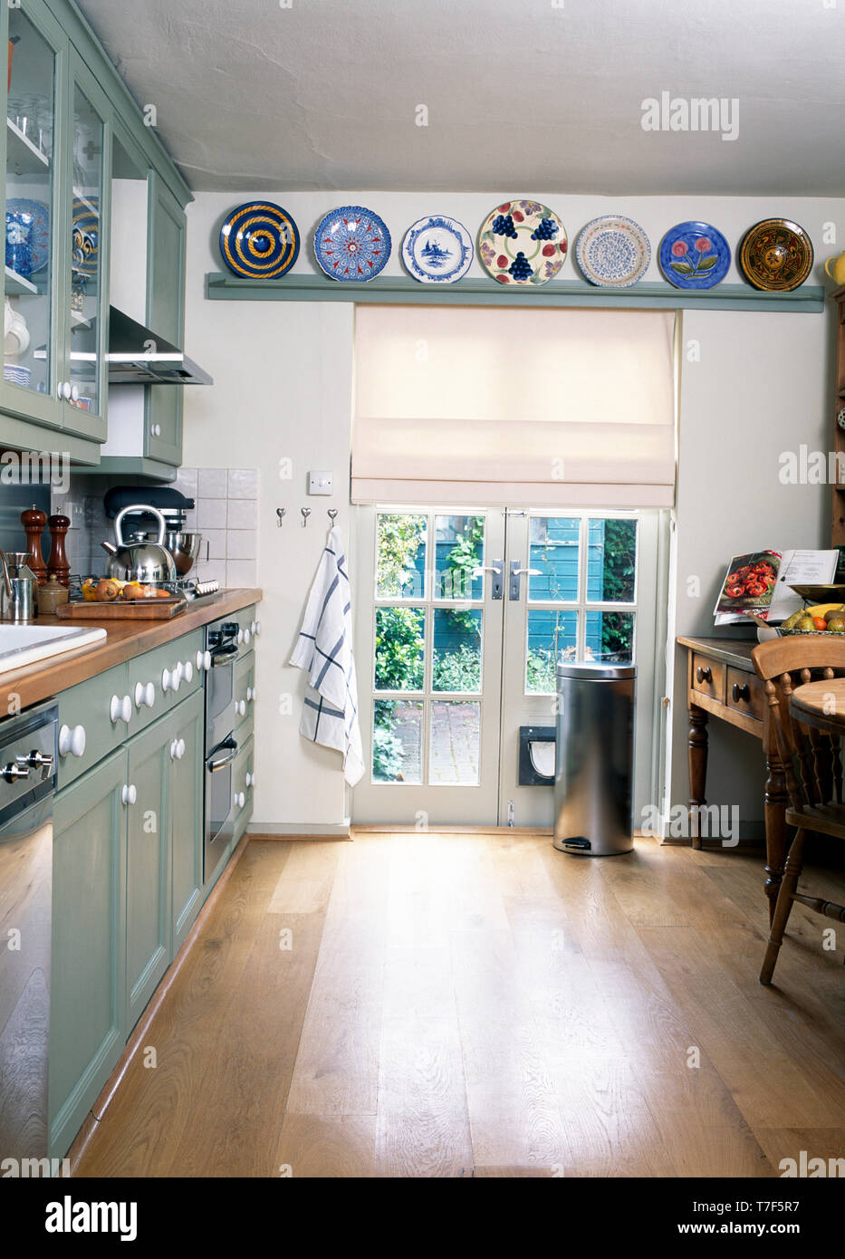 Plates On Shelf Above French Windows In Modern Kitchen Stock Photo Alamy