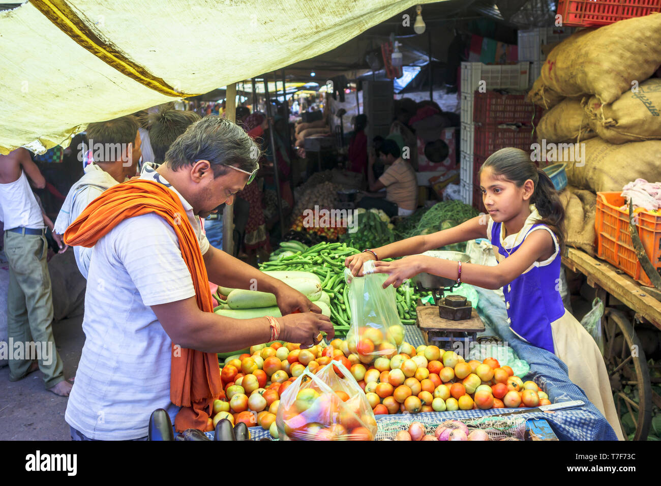 Young girl working in a local market serving fruit and vegetables from a stall in Shahpura, Dindori district, central Indian state of Madhya Pradesh Stock Photo