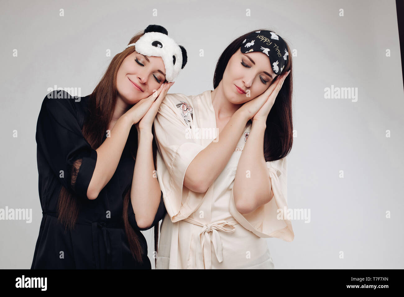 Two young tired girls wearing pajamas sleeping Stock Photo