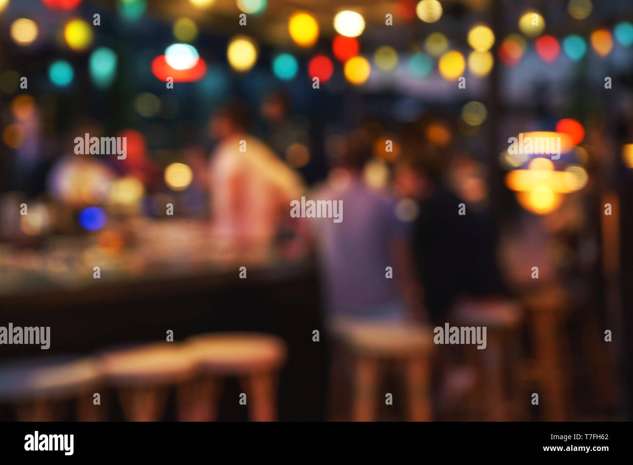 Blurred background of people sitting at restaurant, bar or night club with  colorful lights bokeh Stock Photo - Alamy