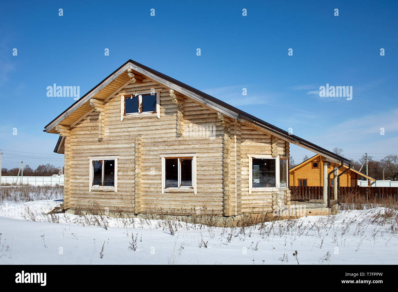 Wooden house at winter, unfinished construction, sunny day Stock Photo