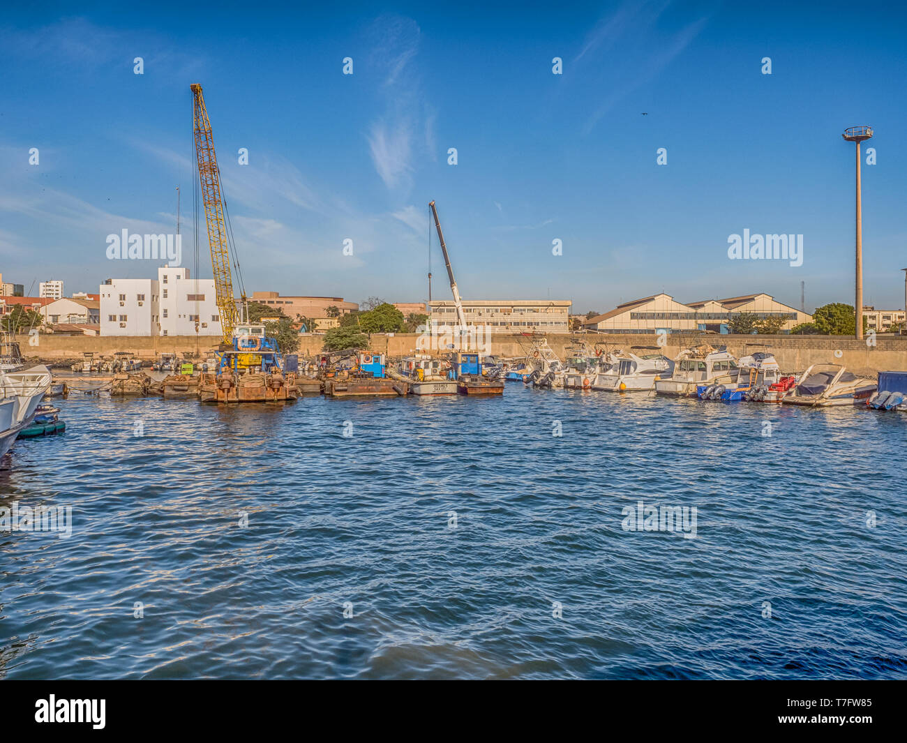 Dakar, Senegal - February 2, 2019: View of the port of Dakar in Senegal with big ships, small boats, cranes and cargos near the quay. Africa. Stock Photo