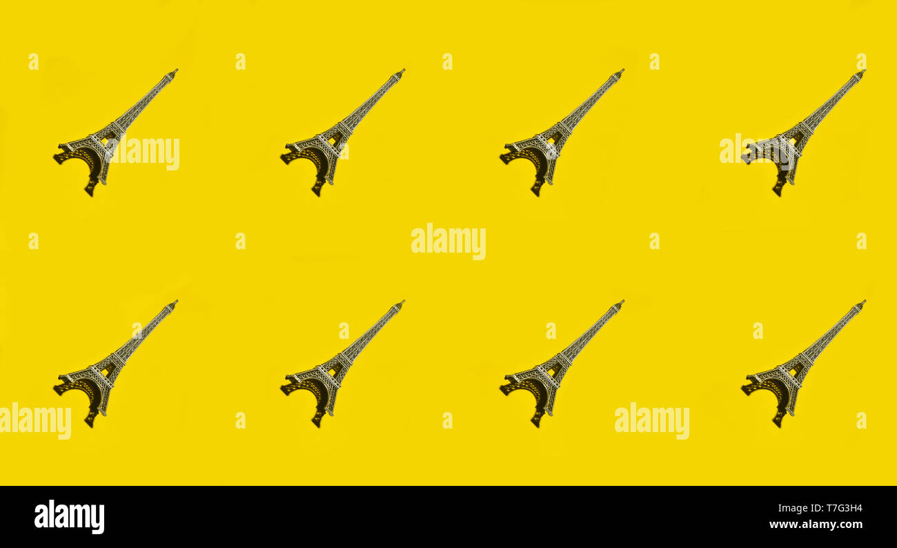 Creative background of statuettes of the eiffel tower on a yellow ...