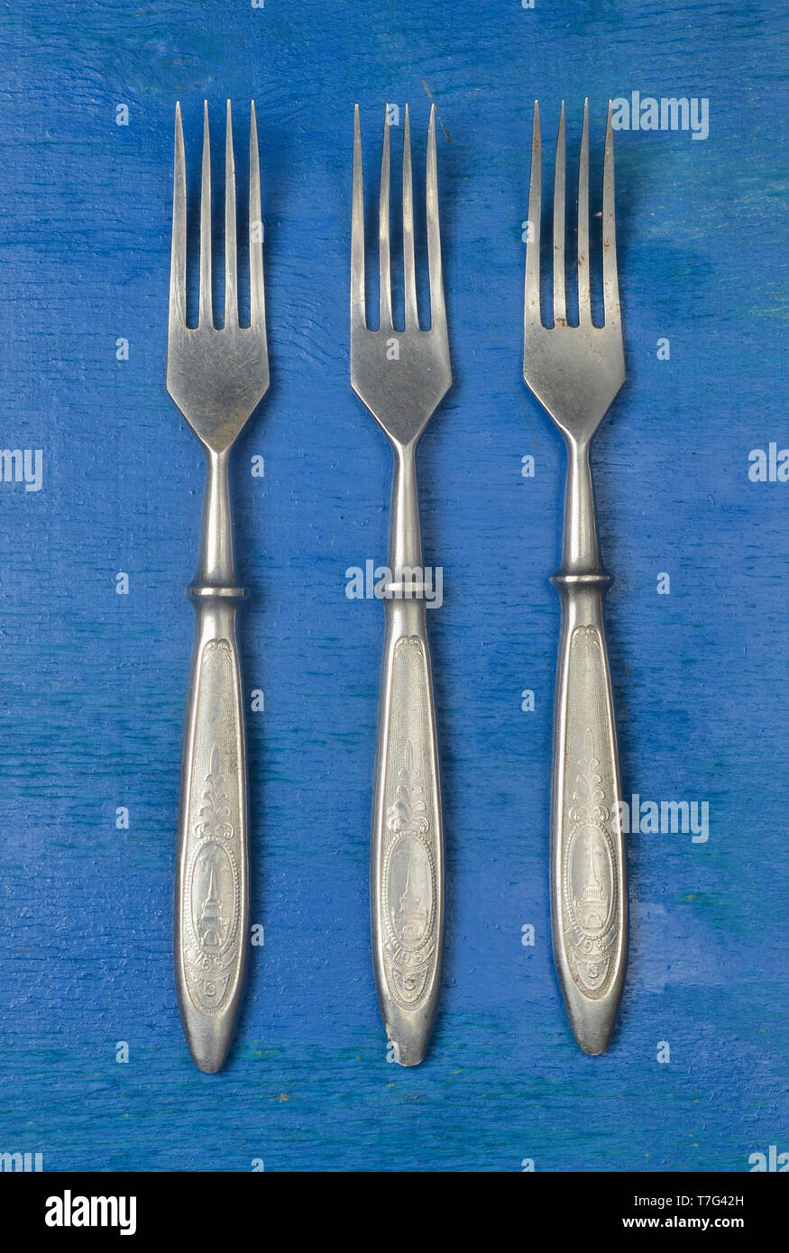 A set of forks on a blue wooden surface. Top view. Stock Photo