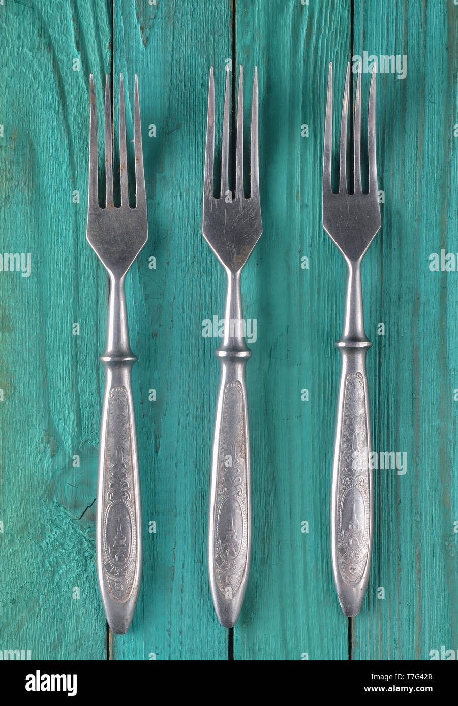 A set of forks on a green wooden surface. Top view. Stock Photo