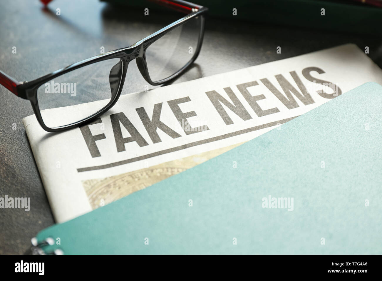 Newspaper with notebook and glasses on table Stock Photo