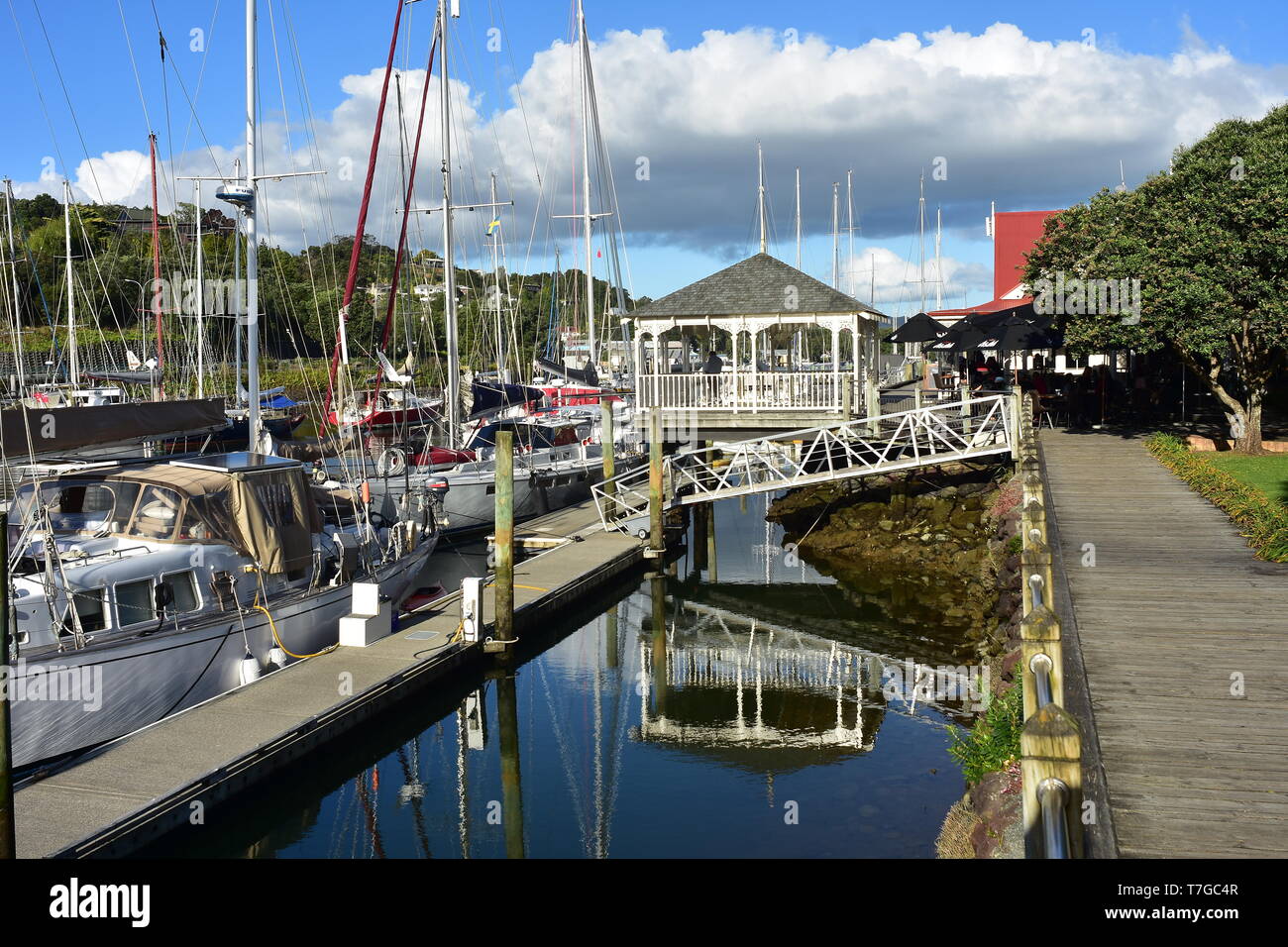 Sailboats at floating jetty connected with mainland by pedestrian bridge in marine in town basin of Whangarei. Stock Photo