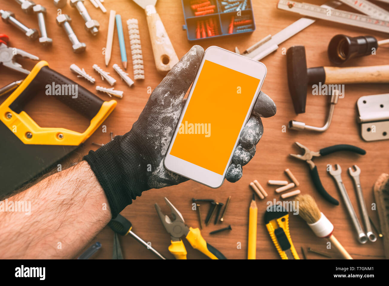 Handyman smartphone app with blank screen. Repairman holding telephone in hand. Copy space for text or maintenance work mobile phone application or bu Stock Photo