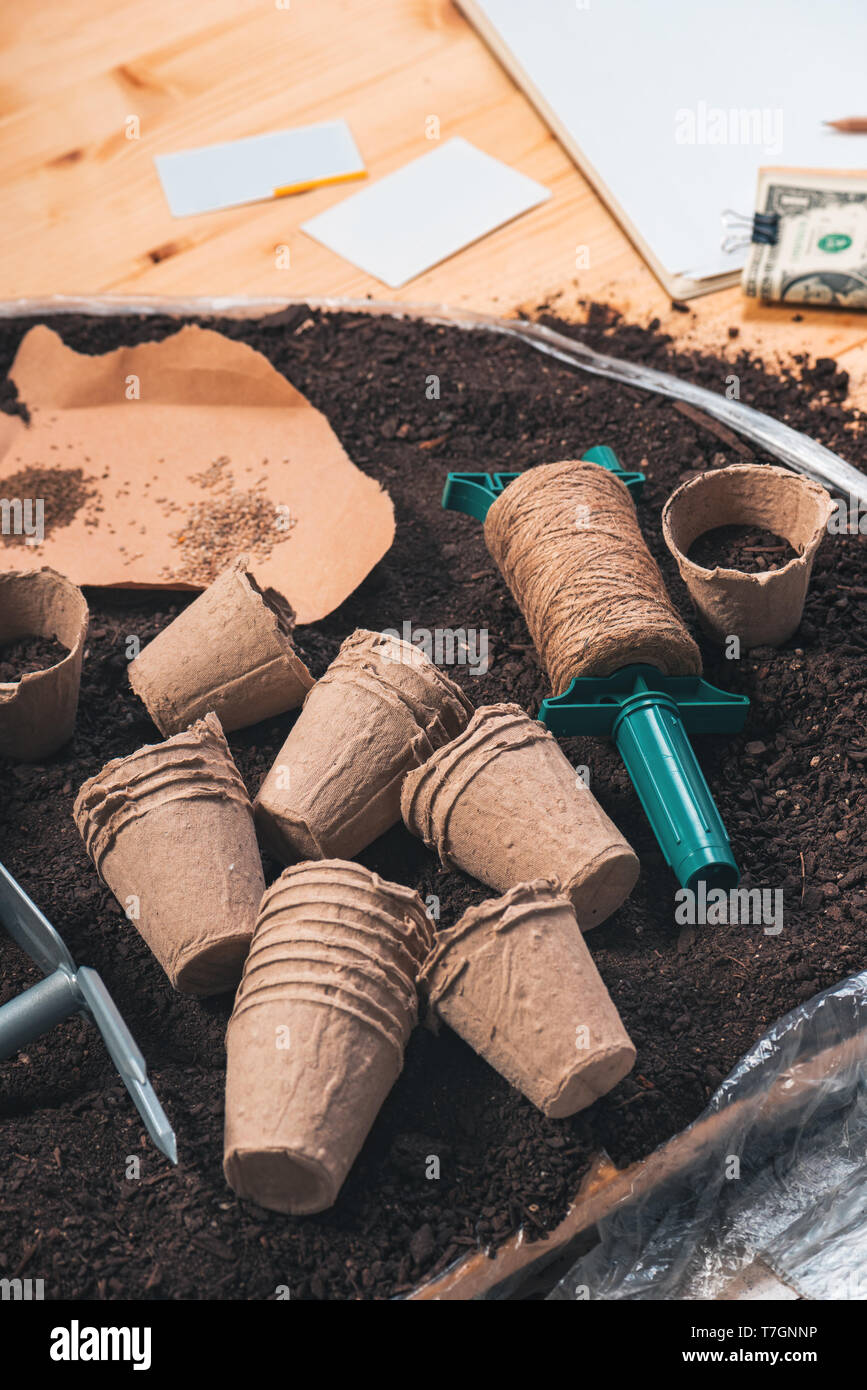 Biodegradable flowerpots in soil, tools and equipment for agricultural activity Stock Photo