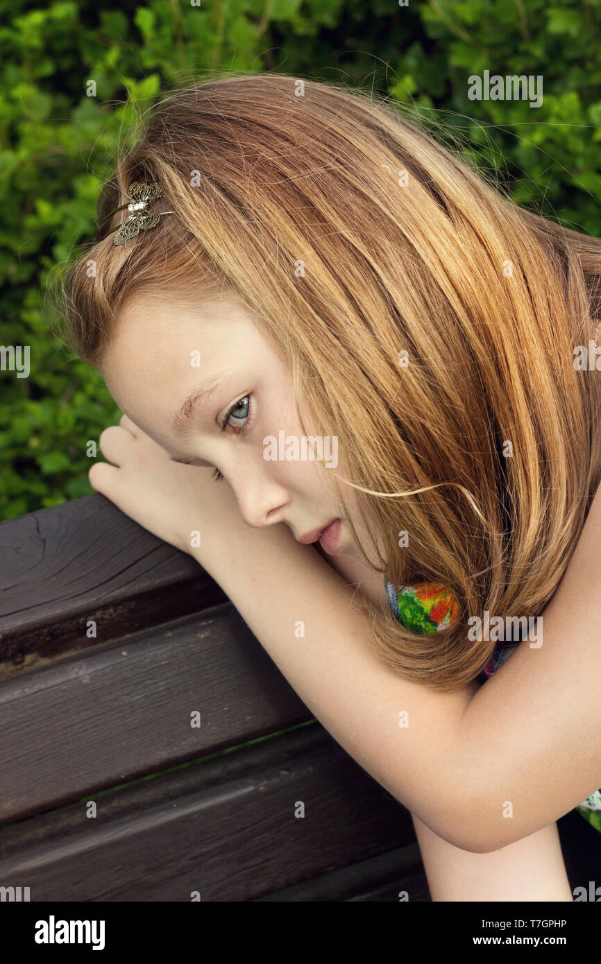 Sad girl sitting on bench hi-res stock photography and images - Alamy