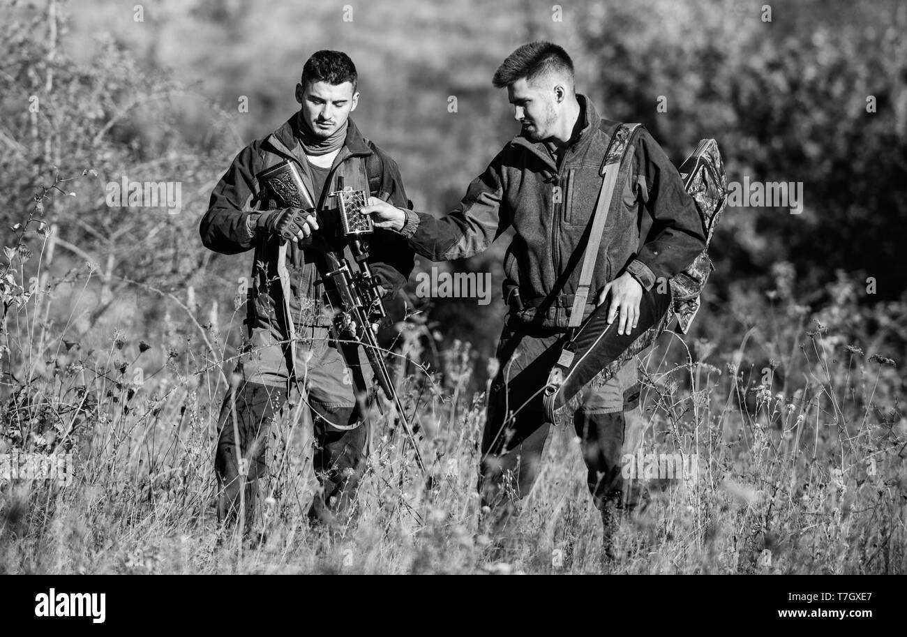 Friendship of men hunters. Military uniform fashion. Army forces. Camouflage. Hunting skills and weapon equipment. How turn hunting into hobby. Man hunters with rifle gun. Boot camp. for success. Stock Photo