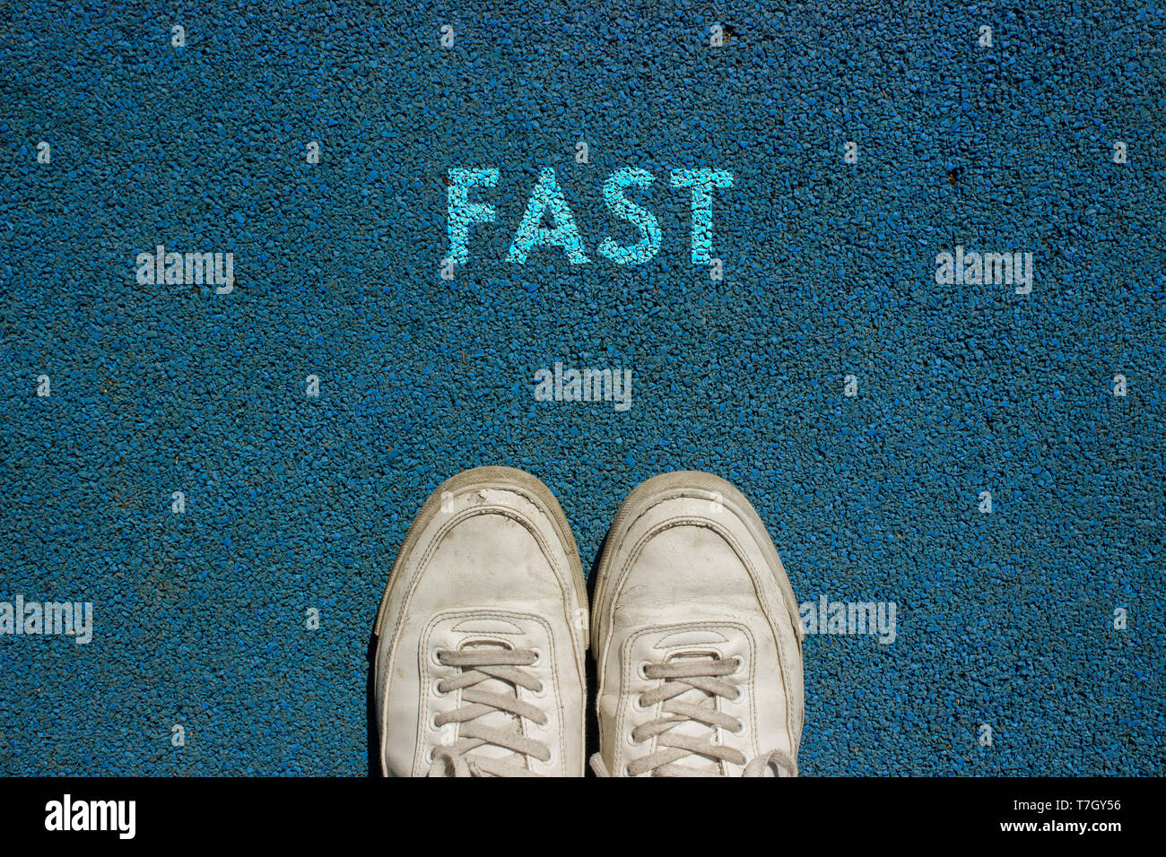 New life concept, Sport shoes and the word FAST written on walk way ground, Motivational slogan. Stock Photo