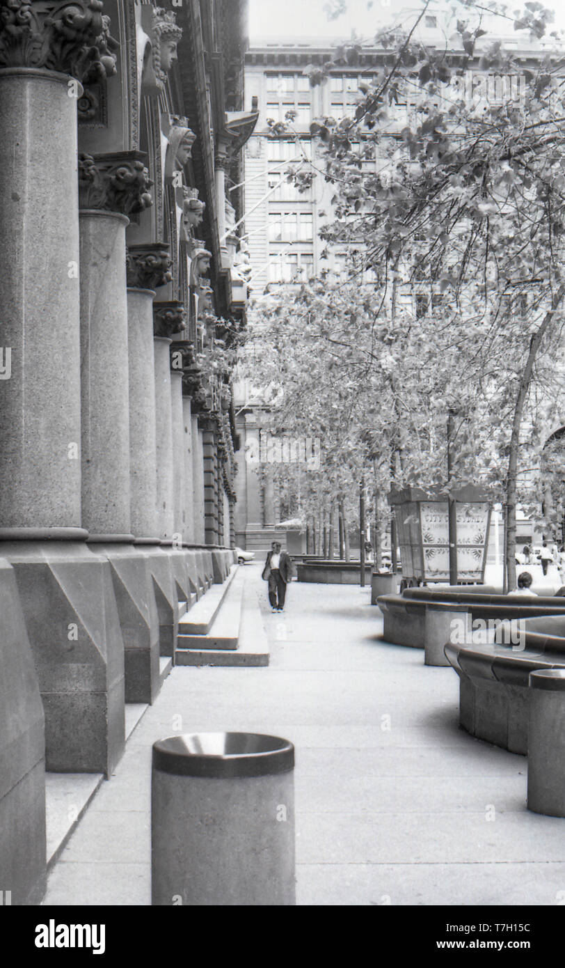 1977 Martin Place, Sydney Australia: A poorly dressed person, possibly a vagrant or homeless person walks along the front of the GPO (General Post Office). Around this time it was common for homeless people to sleep on the doorways of the post office, away from rain and wind. Stock Photo