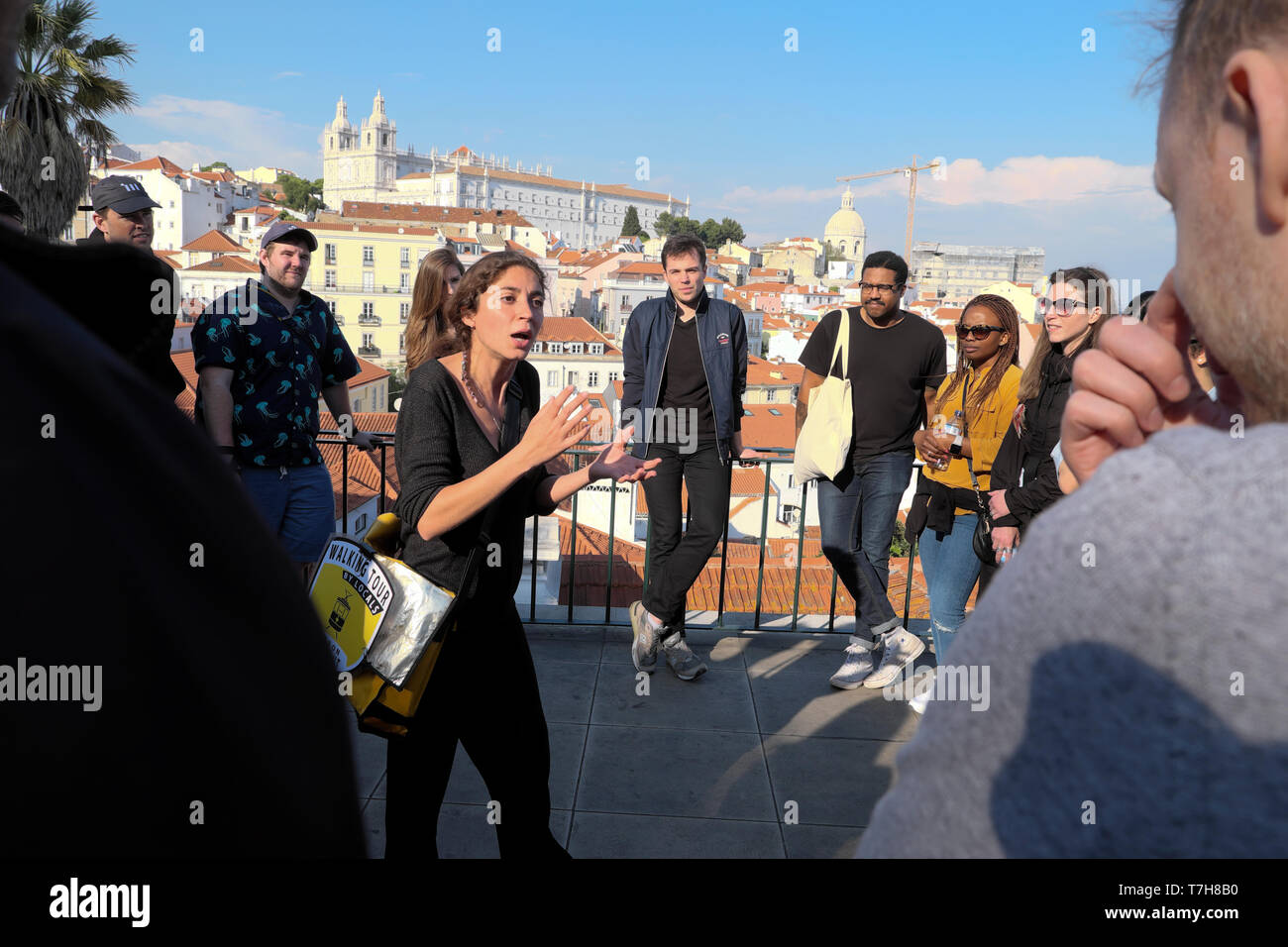 Young woman tour guide giving historical talk about Portuguese history to tourists on holiday in Alfama Lisbon Portugal Europe EU  KATHY DEWITT Stock Photo