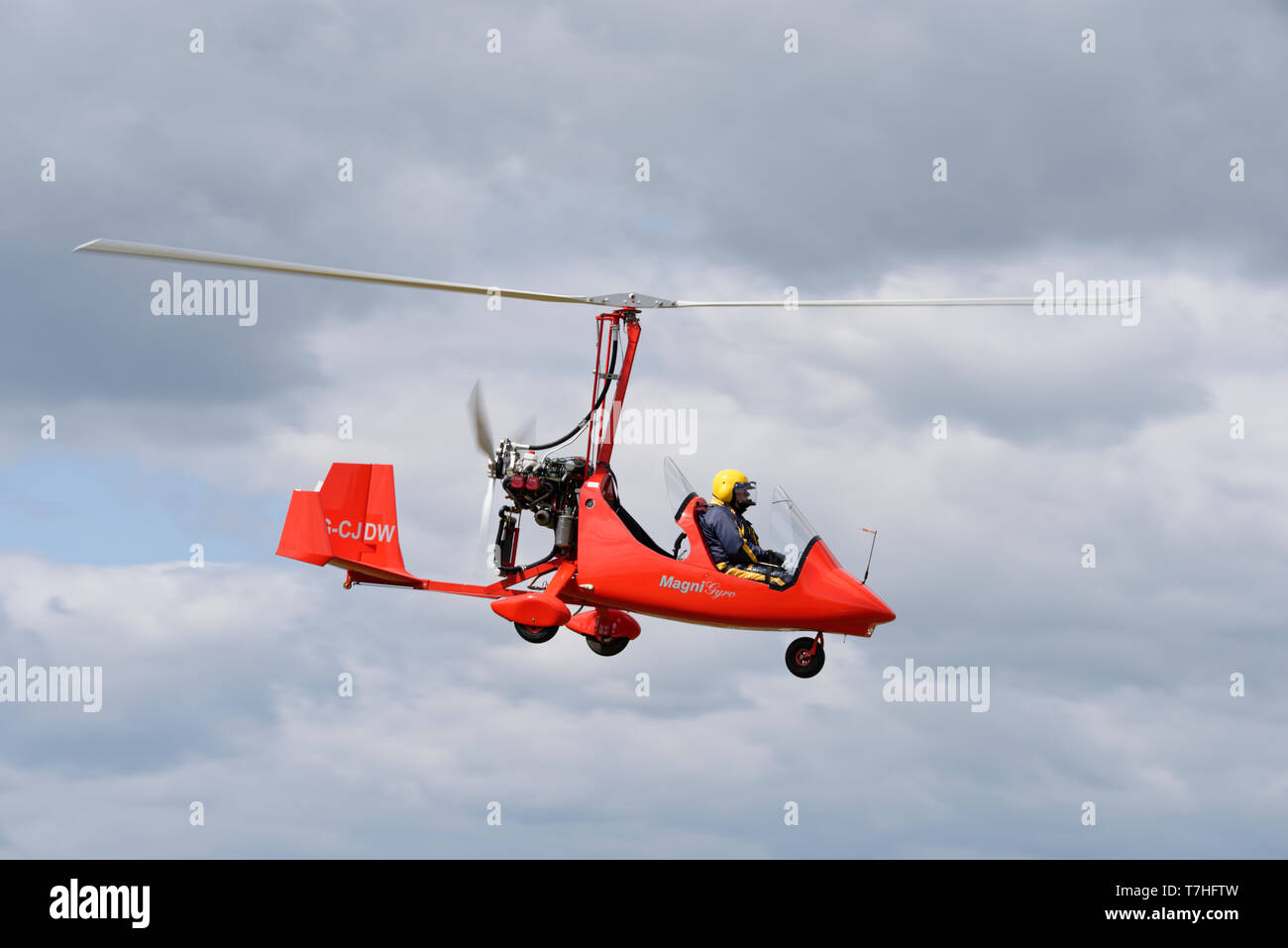 G-CJDW a bright red Magni M16C gyrocopter descends into Popham airfield during the Spring microlight aviation fly-in event Stock Photo