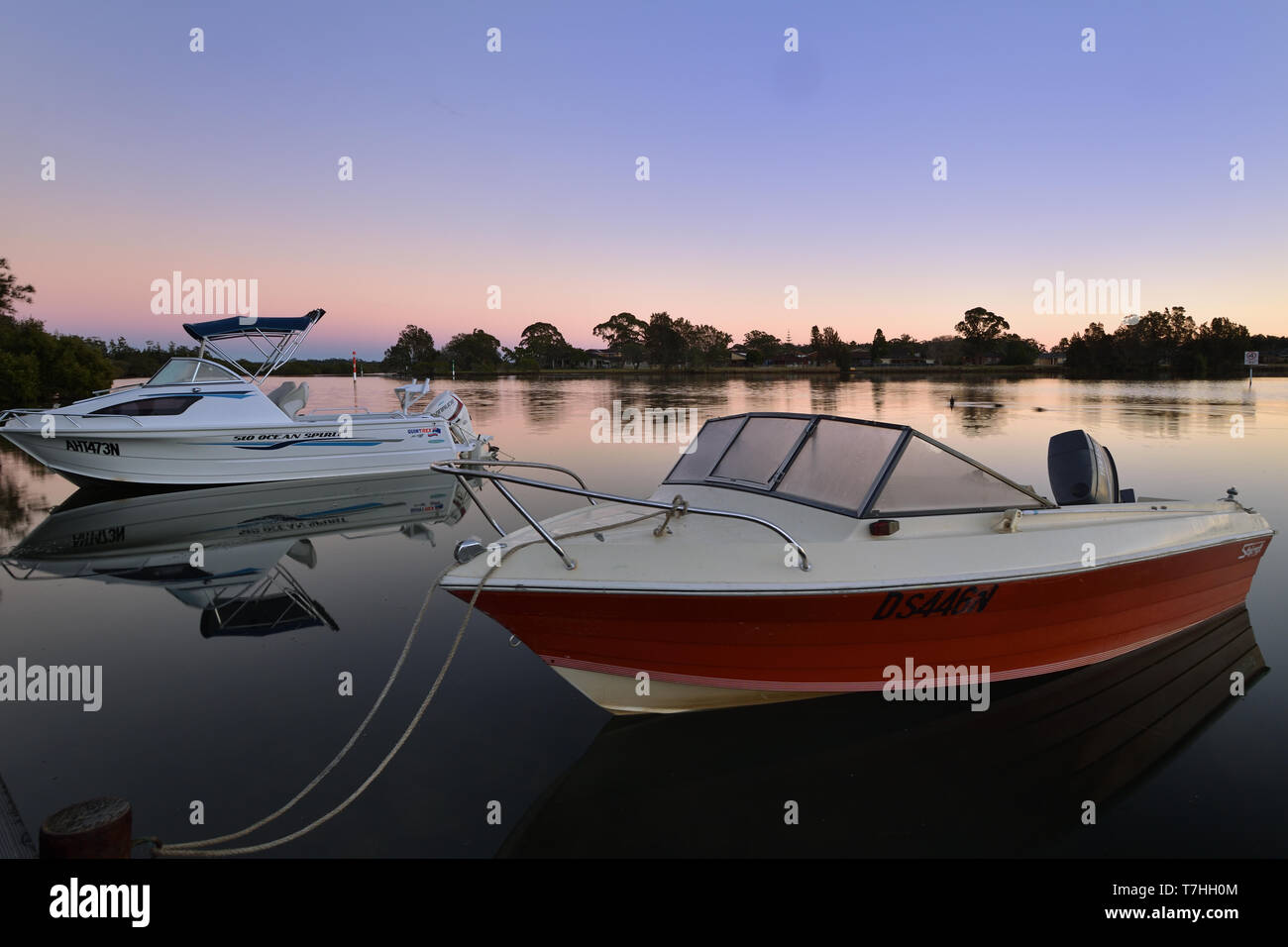 two boats float on the water at dawn Stock Photo Alamy