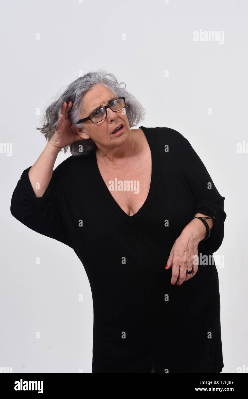 woman putting a hand on her ear because she can not hear on white background Stock Photo